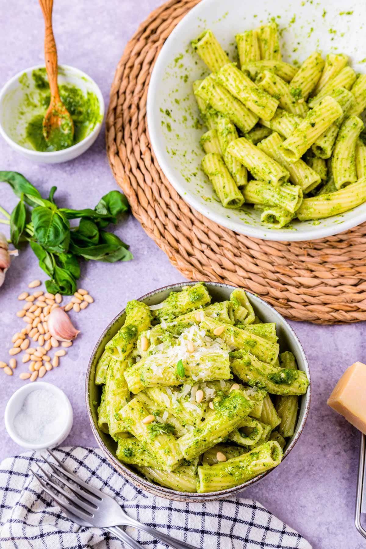 pesto pasta served in a bowl with grated cheese on top.