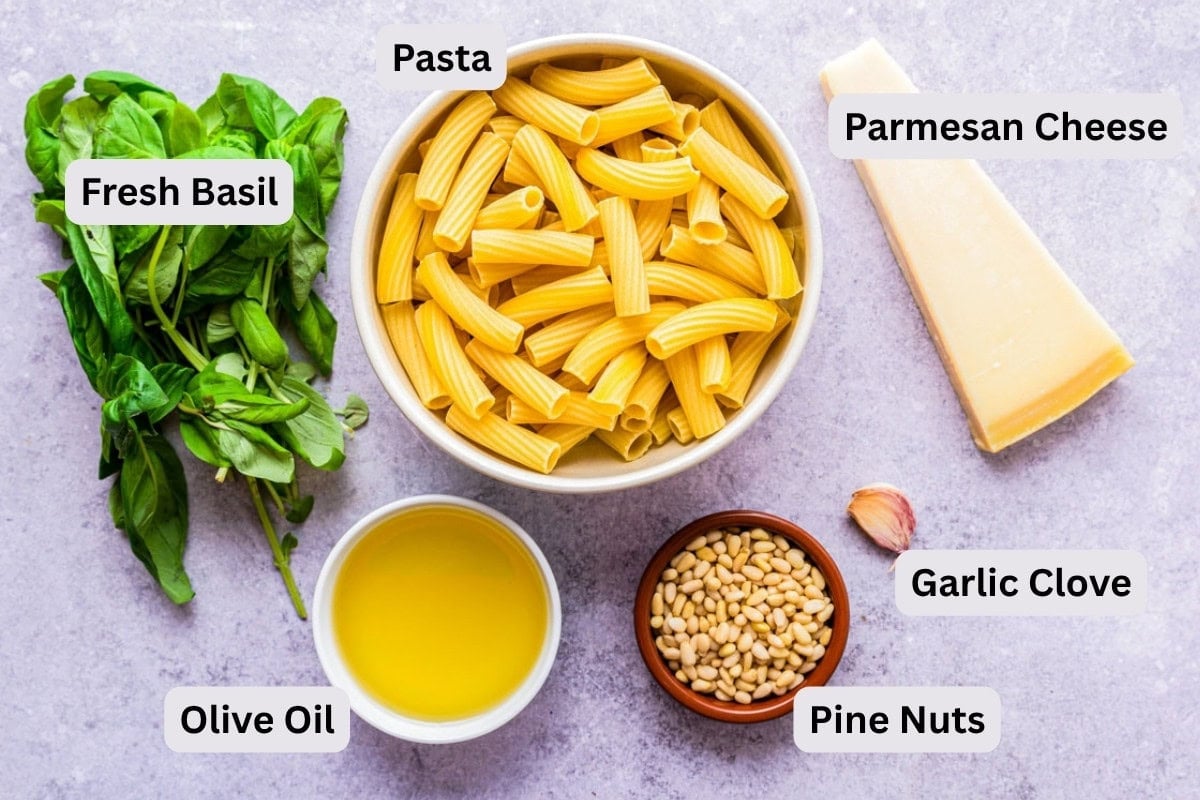 ingredients to make pesto pasta dish on counter with labels.