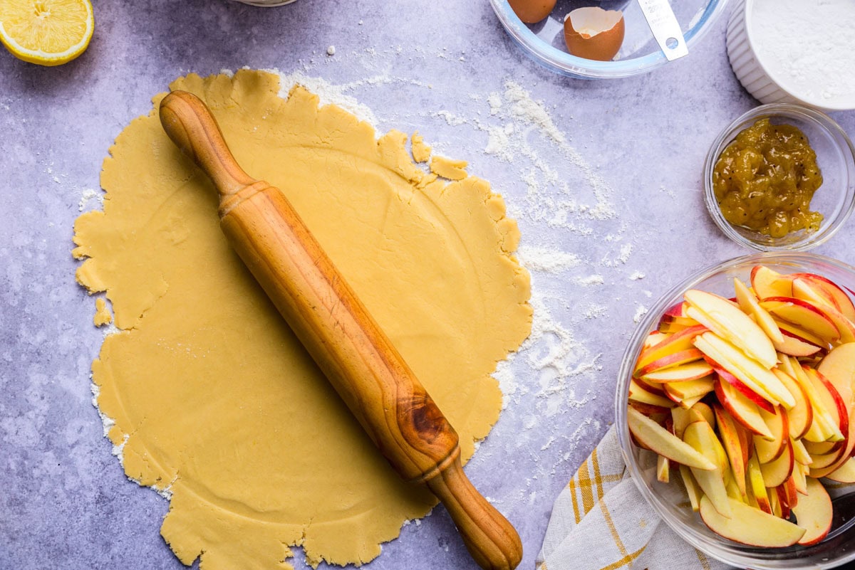 wooden rolling pin rolling our dough on counter.
