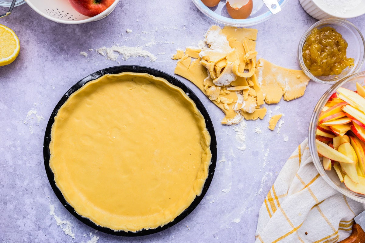 raw crostata dough in form on counter.