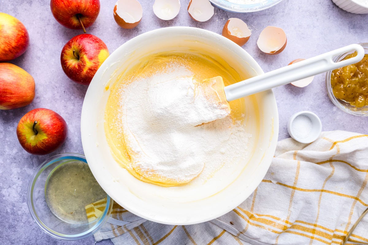 more powdered sugar in bowl of egg butter mixture.