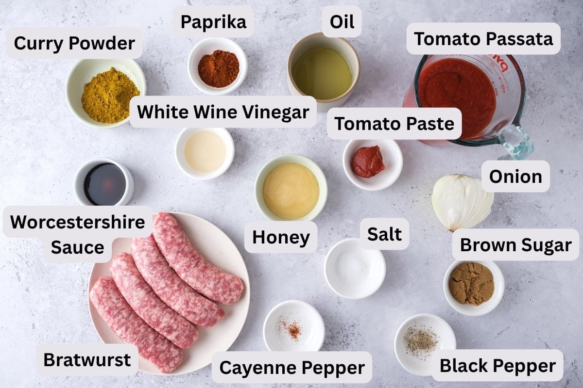 ingredients to make german currywurst on counter in bowls with labels.