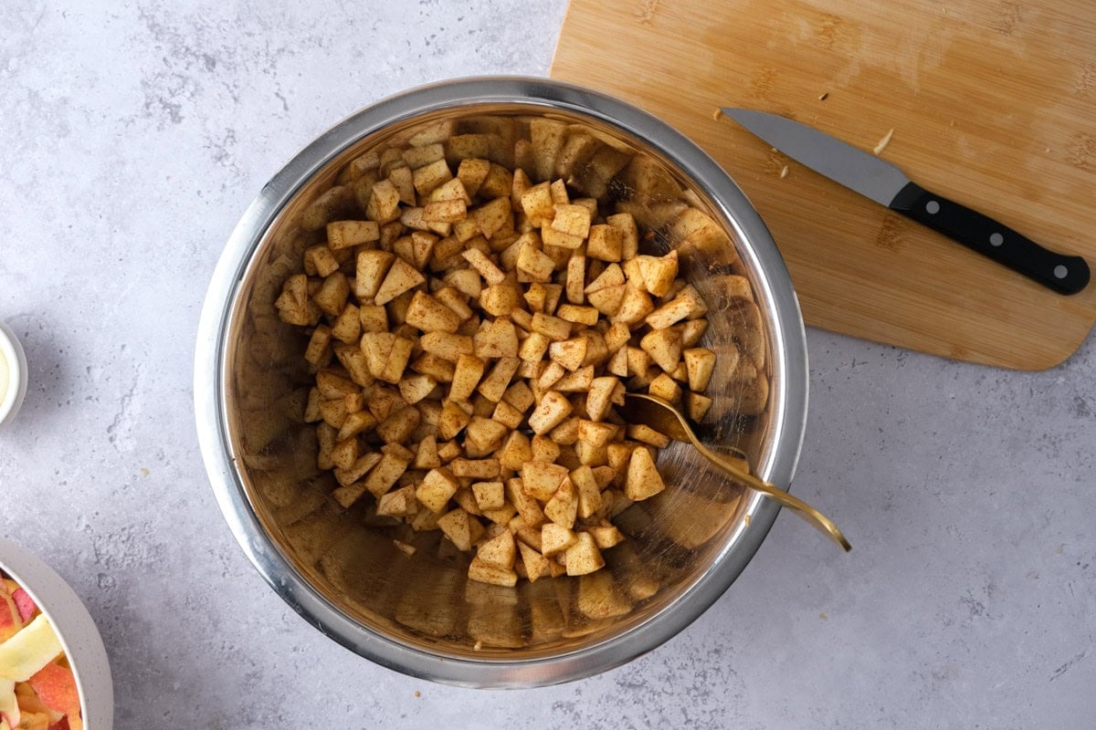 raw apples covered in cinnamon on counter.