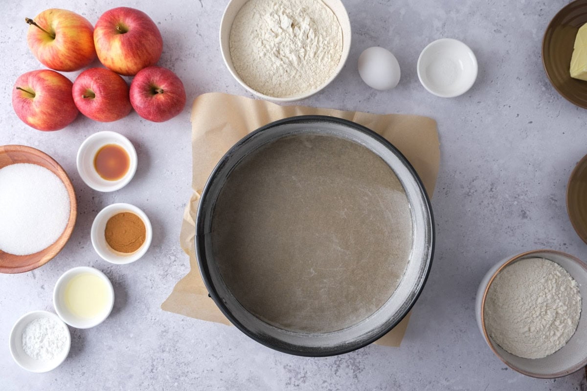 empty cake form on counter with parchment paper inside.